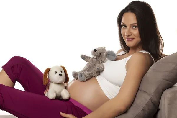 Szczęśliwy Piękne Kobiety Ciąży Leżąc Łóżku Pluszowych Zabawek Białym Tle — Zdjęcie stockowe