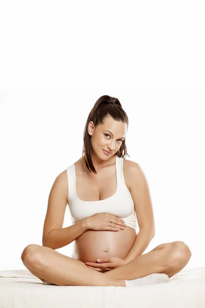 Młoda Kobieta Ciąży Siedząc Łóżku Pozycji Lotosu Białym Tle — Zdjęcie stockowe
