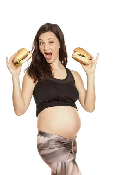 Jonge Zwangere Gulzige Vrouw Houden Twee Hamburgers Een Witte Achtergrond — Stockfoto