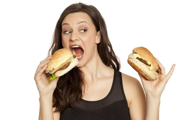 Mladá Krásná Chamtivý Žena Držící Dva Hamburgery Bílém Pozadí — Stock fotografie