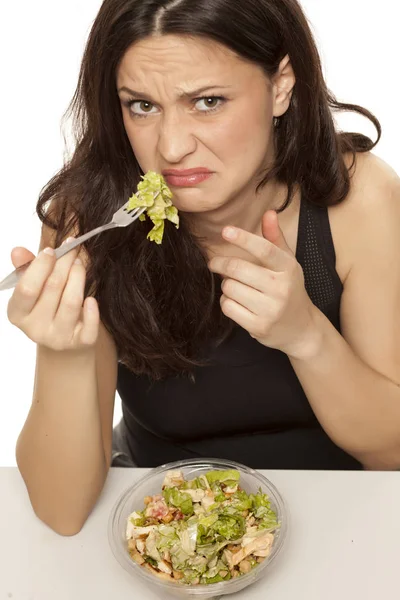 Angewiderte Junge Frau Isst Kaisersalat Auf Weißem Hintergrund — Stockfoto