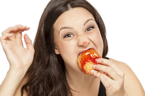 渴望在白色背景下吃樱桃顶面甜甜圈的年轻女子 — 图库照片