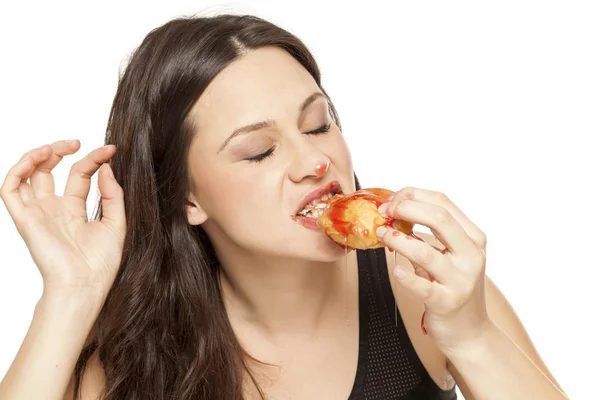 白い背景にドーナツをトッピングに桜を食べる若い女性を渇望 — ストック写真