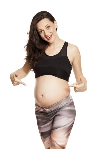 Mooie Lachende Zwangere Vrouw Poseren Een Witte Achtergrond Wijzend Haar — Stockfoto