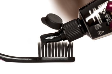 Beyaz bir arka plan üzerinde siyah diş fırçası üzerinde aktif kömür ile siyah diş Yapıştır