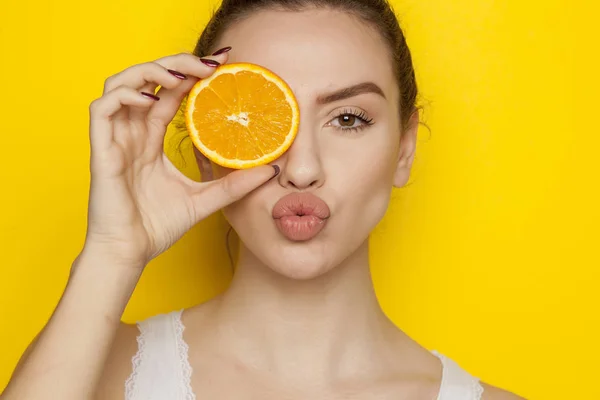 Jovem Posando Com Fatia Laranja Seu Rosto Fundo Amarelo — Fotografia de Stock