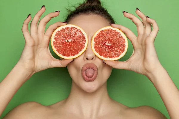 Сексуальная Молодая Женщина Позирует Ломтиками Красного Грейпфрута Лице Зеленом Фоне — стоковое фото