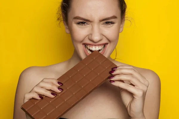 Feliz Joven Mujer Disfrutando Comer Chocolate Sobre Fondo Amarillo —  Fotos de Stock