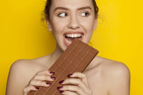 Glückliche Junge Frau Genießt Das Essen Von Schokolade Auf Gelbem — Stockfoto