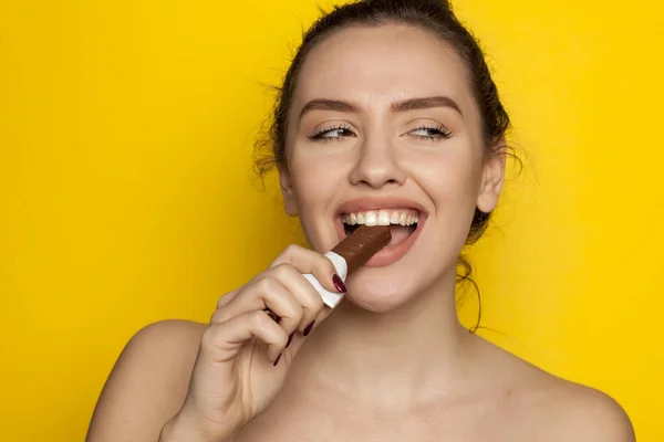 Feliz Joven Mujer Disfrutando Comer Chocolate Sobre Fondo Amarillo —  Fotos de Stock
