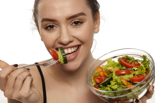 白い背景の上にサラダを食べる若い美しい女性 — ストック写真