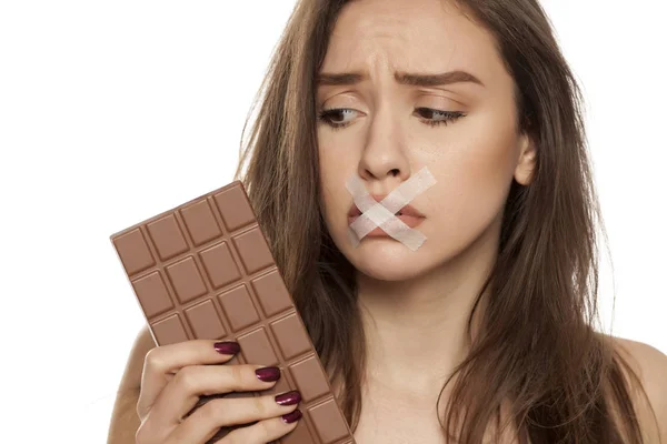 Ung Kvinna Sug Efter Choklad Med Tejpade Munnen Vit Bakgrund — Stockfoto