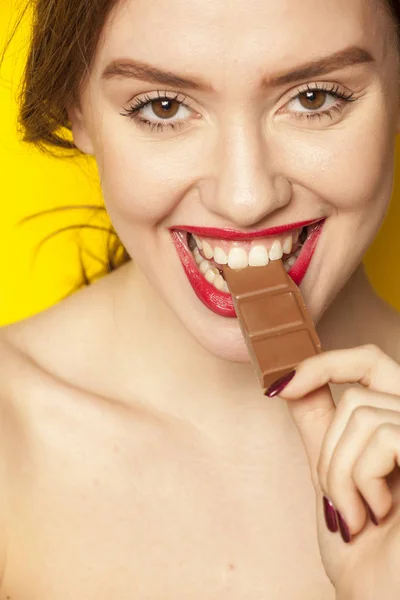 Joven Hermosa Mujer Comiendo Chocolate Sobre Fondo Amarillo —  Fotos de Stock