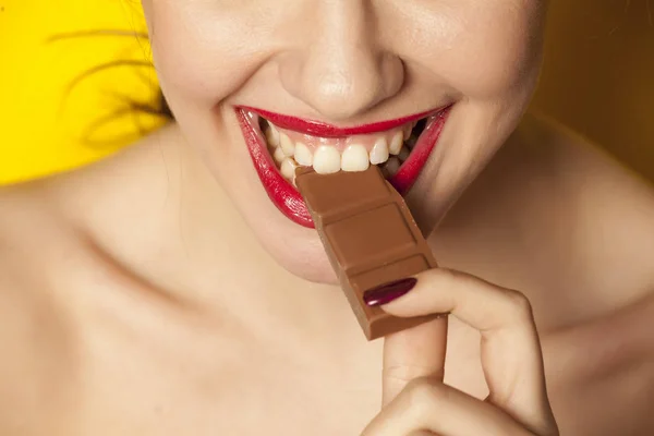 Joven Hermosa Mujer Comiendo Chocolate Sobre Fondo Amarillo —  Fotos de Stock