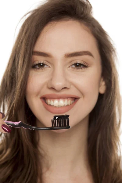 Jovem Segurando Uma Escova Dentes Preta Com Pasta Dente Preta — Fotografia de Stock