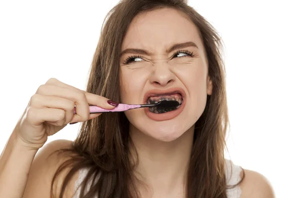 Genç Kadın Beyaz Bir Arka Plan Üzerinde Siyah Diş Yapıştır — Stok fotoğraf