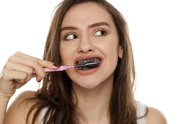 Молода Жінка Чистить Зуби Чорною Зубною Пастою Активним Вугіллям Білому — стокове фото