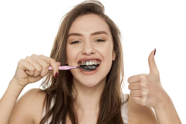 Mladá Žena Kartáčky Zuby Černá Zubní Pastou Aktivním Uhlíkem Ukazuje — Stock fotografie
