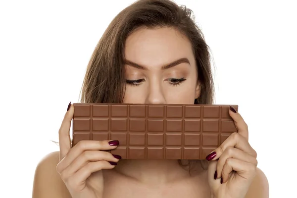 Mladá Krásná Žena Pokrývá Polovinu Obličeje Velkým Barem Čokolády Bílém — Stock fotografie