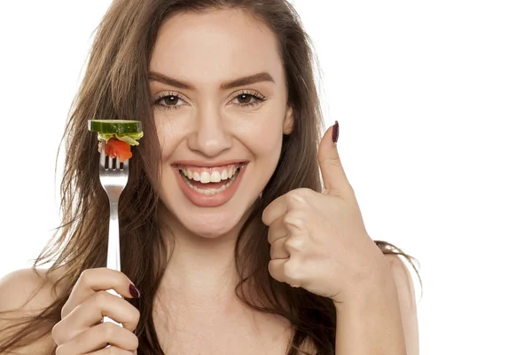 年轻美丽的妇女拿着一个叉子与沙拉在白色背景 — 图库照片