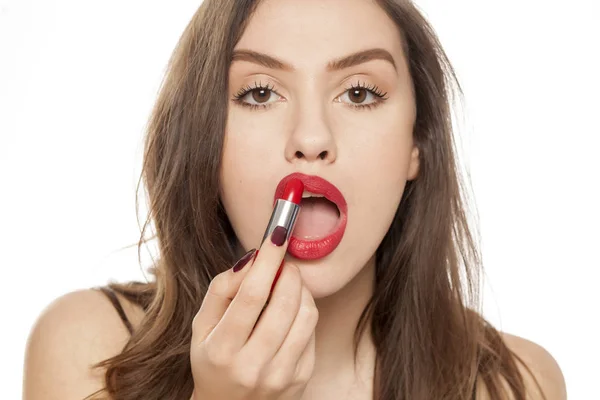 Mooie Jongedame Toepassing Van Rode Lippenstift Een Witte Achtergrond — Stockfoto