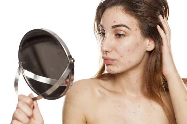 Young Woman Problematic Skin Makeup Looking Herself Mirror White Background — Stock Photo, Image