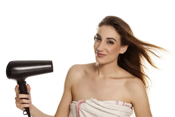 年轻美丽的妇女烘干她的头发与吹风机在白色背景 — 图库照片