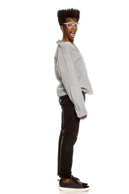 Profil görünümü bir genç yakışıklı Afro Amerikan şık hipster adam ayakta beyaz bir arka plan üzerinde izole. insanlar yaşam tarzı kavramı