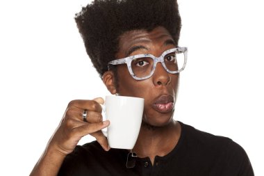 Bir fincan çay beyaz bir arka planda tutan bir Afrikalı-Amerikalı genç portresi