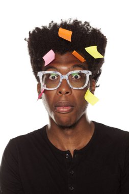 Unutkan ve karışık genç Afro-Amerikan adam kafasını beyaz bir arka plan üzerinde poz çıkartmaları ile