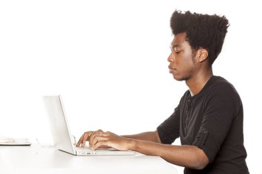 Afrikalı-Amerikalı genç adam bir resepsiyon ile laptop beyaz bir arka plan üzerinde çalışan