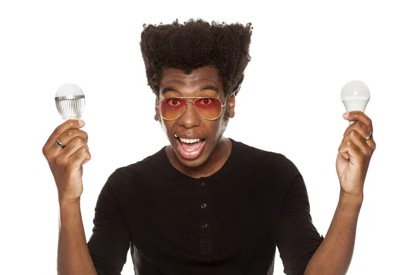 Jovem Afro Americano Bonito Segurando Lâmpadas Led Isoladas Fundo Branco — Fotografia de Stock