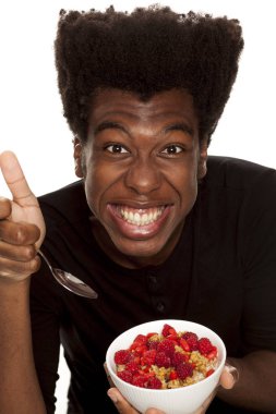 Beyaz bir arka plan üzerinde izole taze meyve ile tahıl yemek genç Afro Amerikan hipster yakışıklı olan. Sağlıklı gıda kavramı