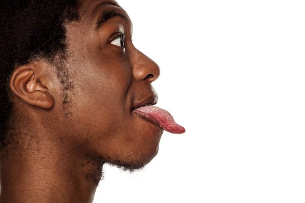彼の舌を突き出し白い背景の上に若い黒人のアフリカ系アメリカ人男のプロフィールを閉じる — ストック写真