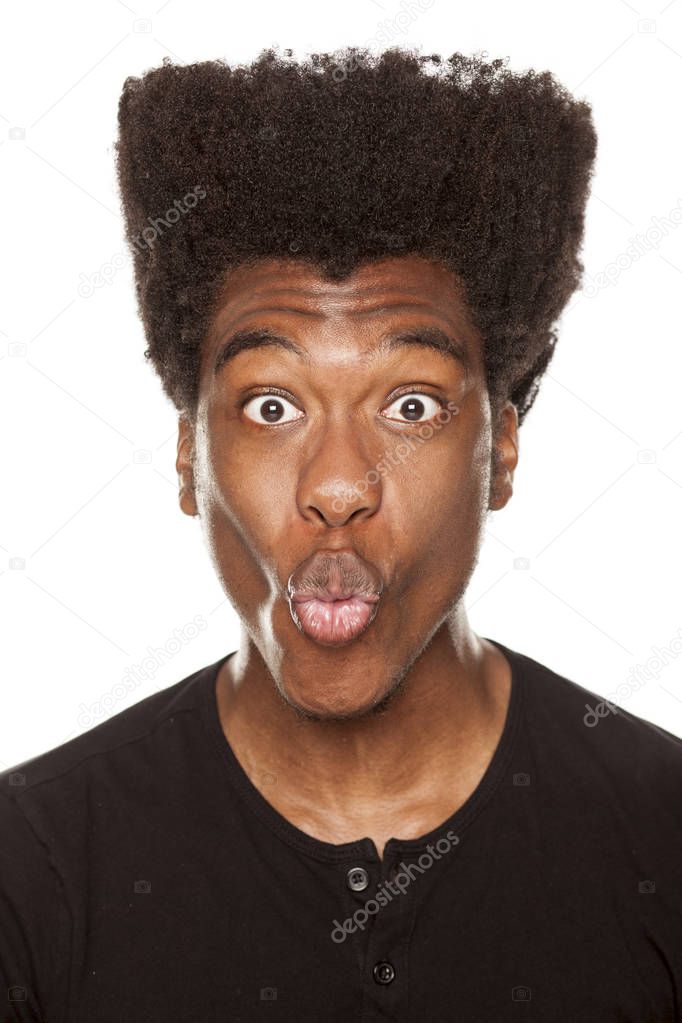 Young African american man making funny face on a white background