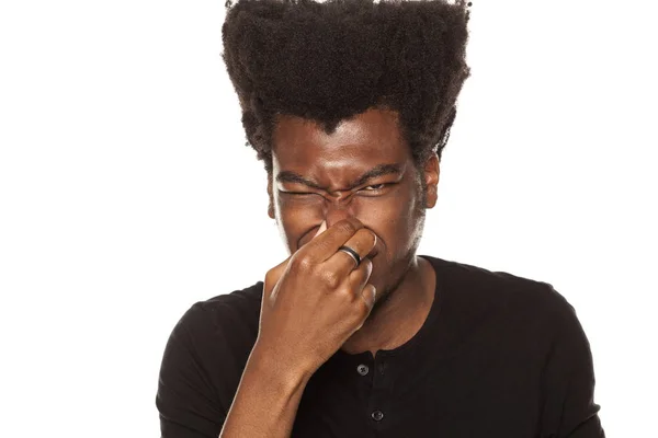 Parmaklarıyla Burnunu Beyaz Zemin Üzerine Kapama Bir Afro Amerikan Genç — Stok fotoğraf