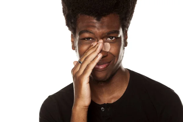 白い背景の彼の鼻に包帯テープで若いアフリカ系アメリカ人の肖像画 — ストック写真