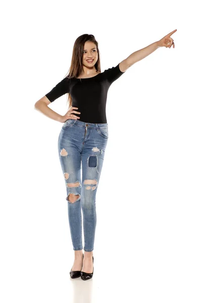 Happy Young Girl Ripped Jeans Pointing White Background — Stok Foto