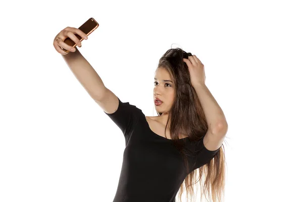 Junges Mädchen Mit Langen Haaren Macht Selfie Auf Weißem Hintergrund — Stockfoto