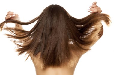 Beyaz bir arka plan üzerinde düz uzun saçlı genç bir çıplak kadın arkadan görünüm