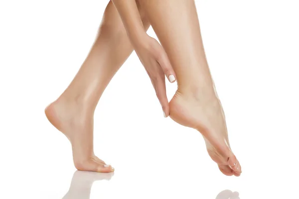 Frau Berührt Zärtlich Ihre Füße Auf Weißem Hintergrund — Stockfoto