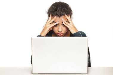 Beyaz arka planda dizüstü bilgisayarında sinirli genç Afrikalı kadın