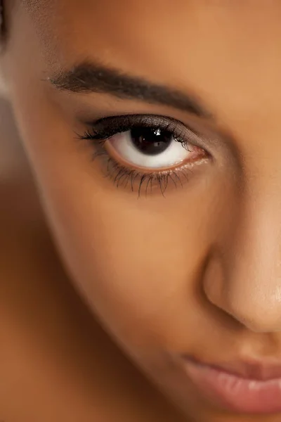 natural eyebrow and eye with makeup of dark skinned female