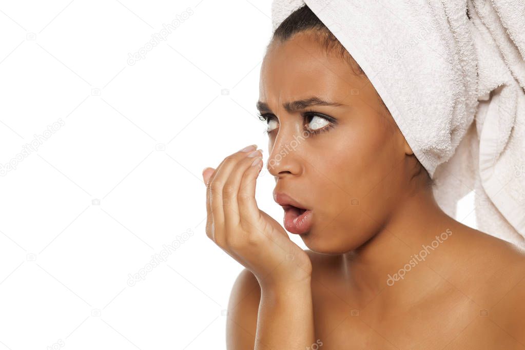 portrait of young beautiful dark-skinned woman checking her breath on a white background