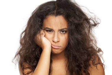 beyaz bir arka plan üzerinde dağınık uzun saçlı mutsuz bir genç koyu tenli kadının portresi