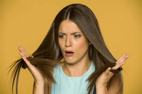 Jovem Chocada Olhando Para Cabelo Fundo Amarelo — Fotografia de Stock