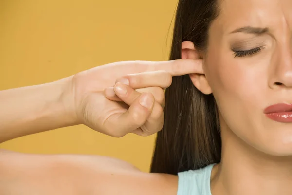 Beautiful Young Woman Finger Her Ear Yellow Background — Stock Photo, Image