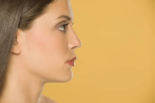Profile of bautiful young woman on yellow background