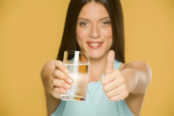 Giovane Donna Sorridente Che Tiene Bicchiere Acqua Mostra Pollici Sfondo — Foto Stock