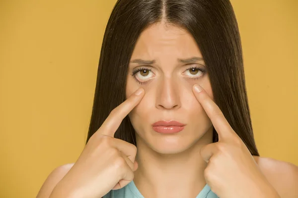 Young Sad Woman Touching Her Low Eyelids Yellow Background — Stock Photo, Image